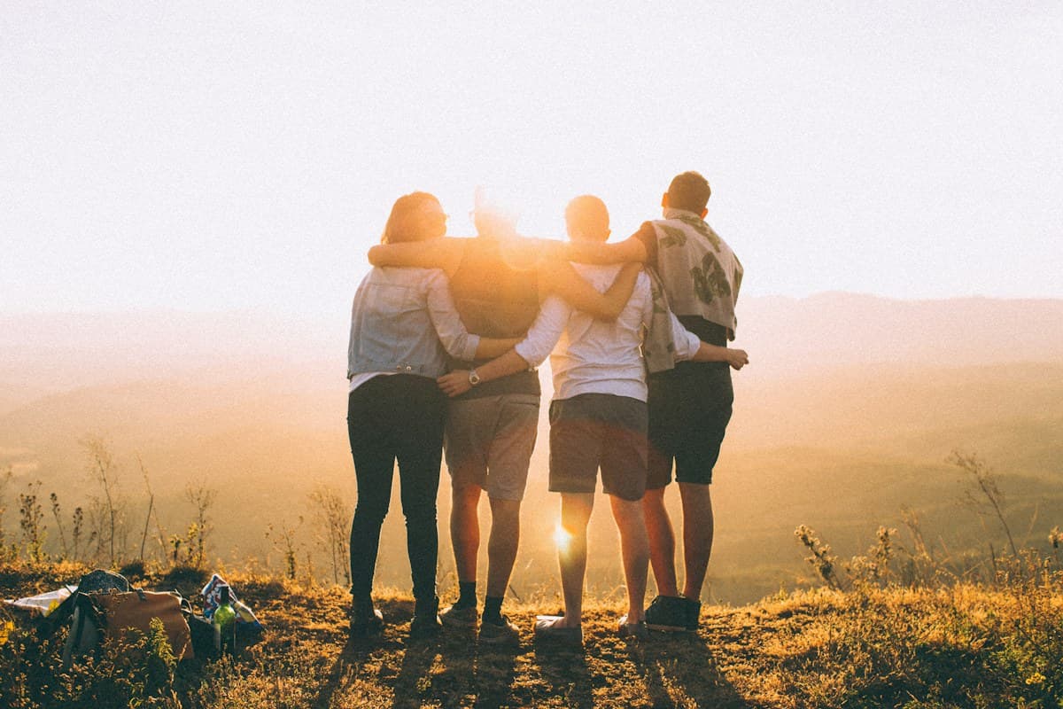 Friends standing together outdoors in the evening light